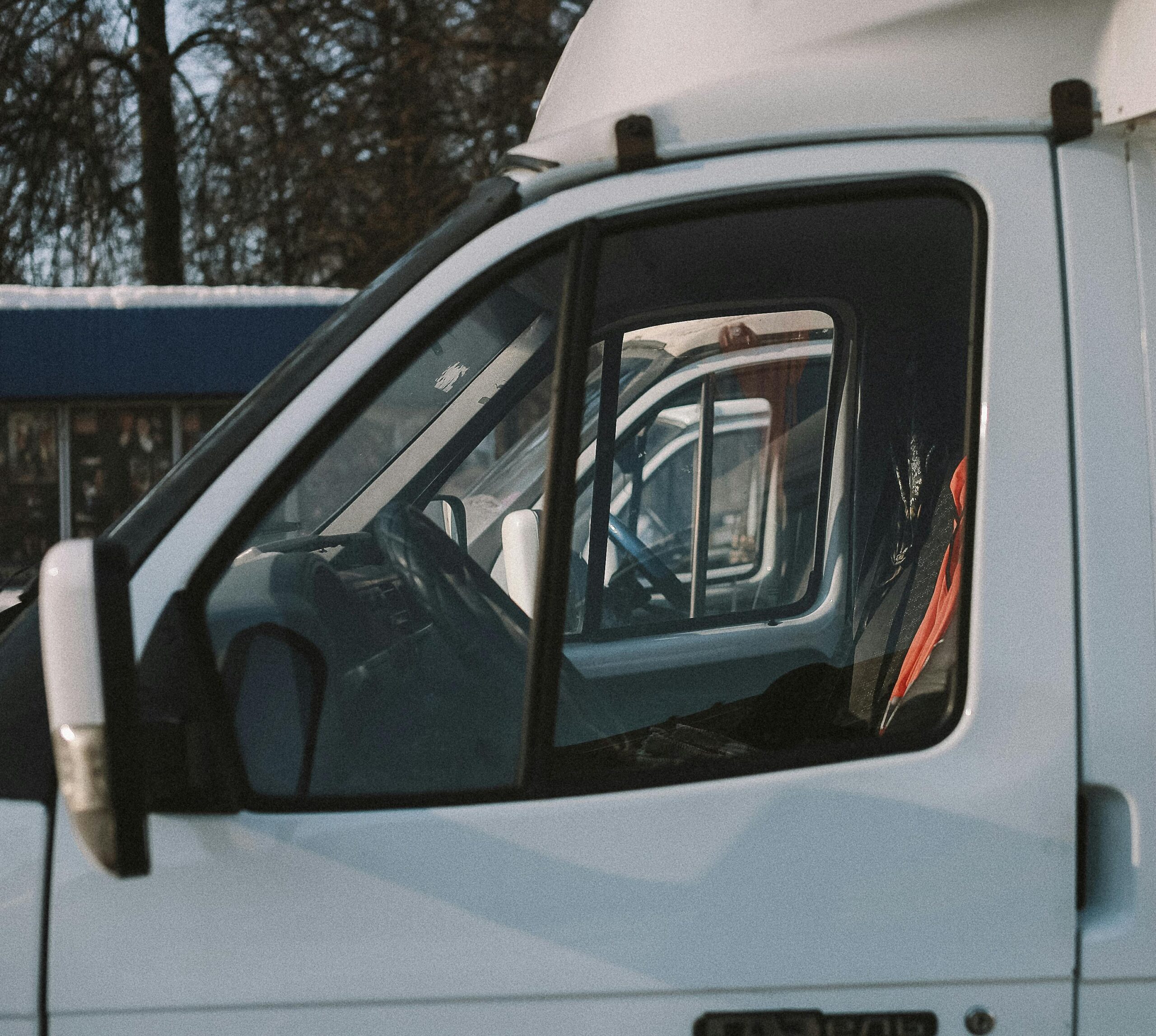 A row of parked camper vans under natural daylight, showcasing their side windows and sleek design.